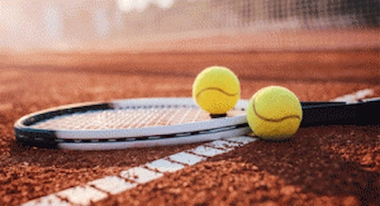 Das Bild zeigt einen Tennisschlager auf einem Aschhenplatz mit 2 Tennisbällen